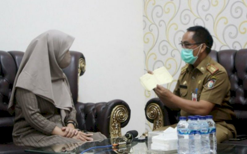 KARTU KESEHATAN. Kepala Dinas Perikanan dan Pertanian Kota Makassar, Abd Rahman Bando, memperlihatkan contoh kartu kesehatan hewan saat memberikan keterangan, Selasa (28/7/2020). foto: anas/pluz.id