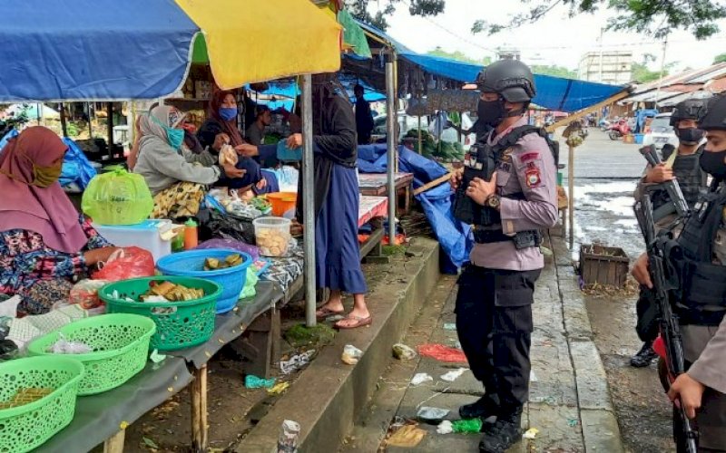 EDUKASI. Personel Batalyon C Pelopor Satuan Brimob Polda Sulsel melakukan edukasi menyambut New Normal di Pasar Sentral, Kamis (9/7/2020). foto: istimewa.