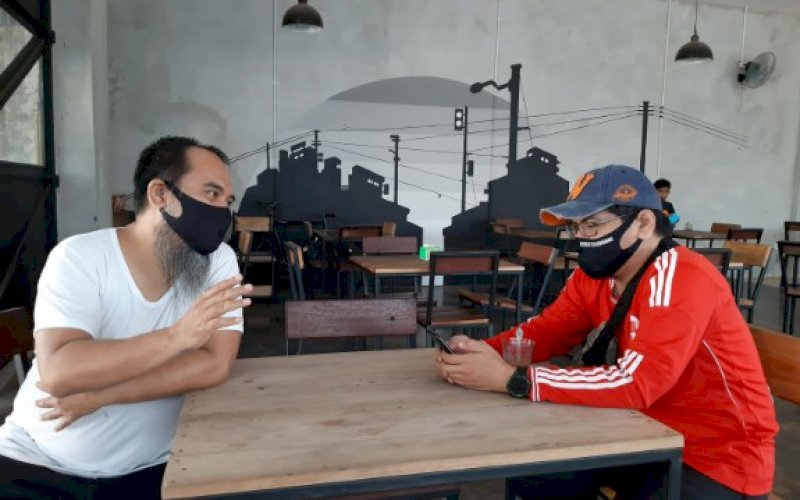JAMU PELANGGAN. Owner Warkop Sija Borong, Zaldy Darmawan (kiri), menjamu dan berbincang dengan salah satu pelanggan, Sabtu (4/7/2020). foto: doelbeckz/pluz.id