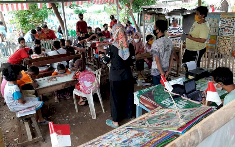 BELAJAR ONLINE. Pelajar tingkat SD sedang mengikuti proses belajar sistem online di atas lahan Tempat Pekuburan Umum (TPU) Dadi Makassar, Jumat (3/7/2020). foto: doelbeckz/pluz.id