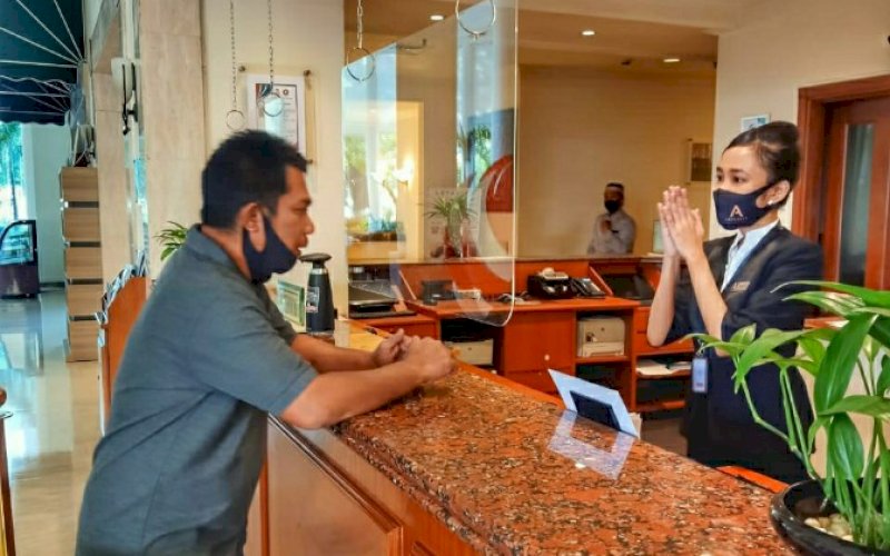 LAYANI TAMU. Recepsionis Aryaduta Makassar melayani tamu dengan ramah. foto: istimewa