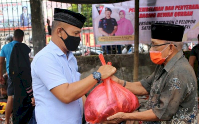 DAGING KURBAN. Danyon C Pelopor, Kompol Nur Ichsan (kiri), menyerahkan daging kurban kepada salah satu penerima di Mako Yon C Pelopor, Bone, Jumat (31/7/2020). foto: istimewa