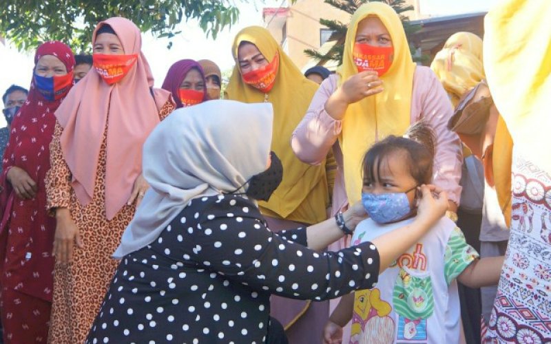 PASANGKAN MASKER. Bakal calon Wakil Wali Kota Makassar, Fatmawati Rusdi, memasangkan masker kepada seorang anak-anak di sela-sela kunjungannya ke Kelurahan Bitowa, Kecamatan Manggala, Kamis (20/8/2020). foto: istimewa