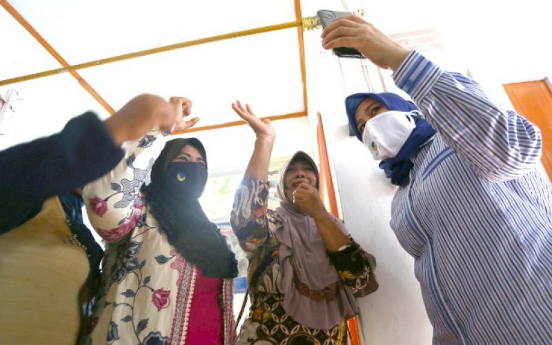 VIDEO CALL. Bakal calon Wakil Wali Kota Makassar Fatmawati Rusdi melakukan video call dengan bakal calon Wali Kota Makassar Moh Ramdhan Pomanto disaksikan warga di Kelurahan Ende, Kecamatan Wajo, Kota Makassar, Selasa (11/8/2020). foto: istimewa