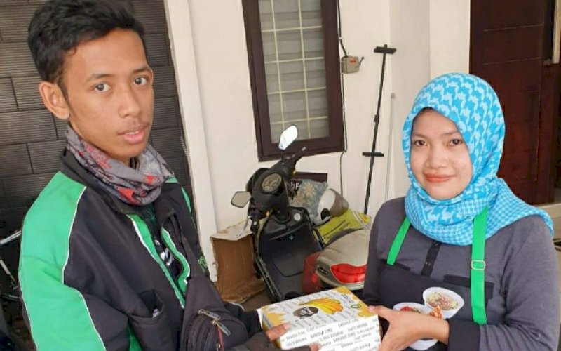 ORDER ONLINE. Seorang tukang Ojek Online (Ojol) menerima orderan Rich Banana's. foto: istimewa