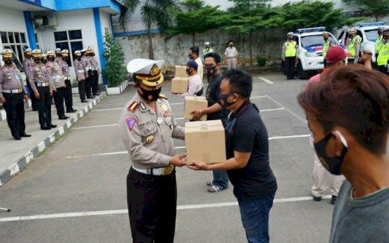 BERBAGI. Dirlantas Polda Sulsel, Kombes Pol Frans Sentoe, menyerahkan paket sembako kepada warga, Kamis (17/9/2020). Kegiatan ini merupakan rangkaian peringatan Hari Lalu Lintas Bhayangkara Ke-65. foto: doelbeckz/pluz.id