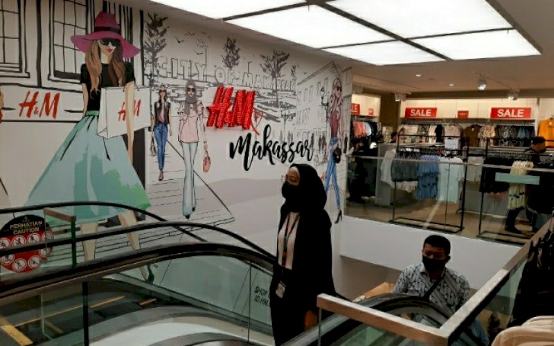 DIBUKA. Pengunjung menaiki tangga eskalator di gerai H&M yang telah dibuka di Mal Ratu Indah (MaRI) Makassar, Jumat (9/11/2020). foto: doelbeckz/pluz.id