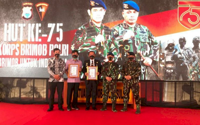 TERIMA PENGHARGAAN. Bupati Luwu Basmin Mattayang (tengah) dan Andi Abdullah Rahim (kedua kiri) selaku perwakilan dari keluarga Andi Rahmat menerima penghargaan dari Kapolda Sulsel Irjen Pol Merdisyam di sela-sela perayaan HUT Korps Brimob ke-75 di Makassar, Sabtu (14/11/2020). foto: istimewa