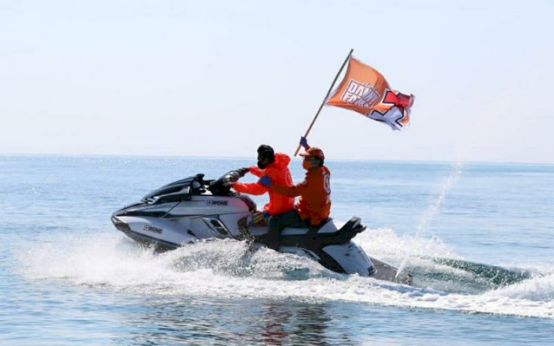BERKIBAR. Calon Wali Kota Makassar, Mohammad Ramdhan Pomanto, memegang bendera Danny-Fatma yang sedang berkibar, saat menaiki jet ski di Pantai Losari, Makassar, belum lama ini. foto: istimewa