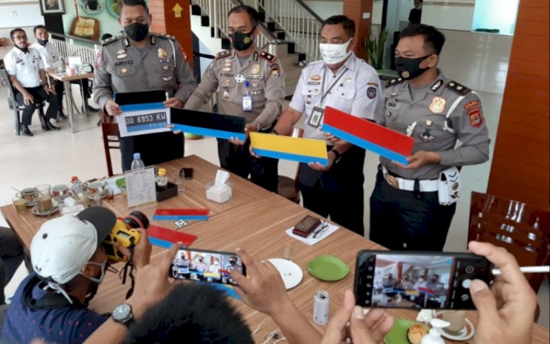 CONTOH PLAT. Kasubdit Regident Ditlantas Polda Sulsel Kompol Muhammad Yusuf (kedua kiri) bersama jajaran dan Kasi Penetapan Pajak Samsat Makassar I HM Majid memperlihatkan contoh plat kendaraan listrik untuk wilayah Sulsel, Rabu (18/11/2020). foto: doelbeckz/pluz.id