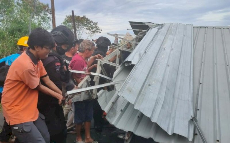EVAKUASI. Personel Batalyon C Pelopor Satbrimob Polda Sulsel membantu warga melakukan evakuasi akibat atap bangunan rubuh yang menimpa jalanan di Kabupaten Selayar, Selasa (8/12/2020) pagi. foto: istimewa