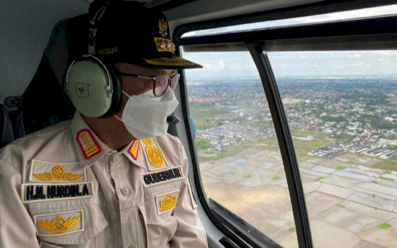 PEMANTAUAN. Gubernur Sulsel, Nurdin Abdullah, melakukan pemantauan lewat udara menggunakan helikopter milik BNPB di Kota Makassar, Gowa, Takalar, dan Jeneponto, Senin (28/12/2020). foto: istimewa