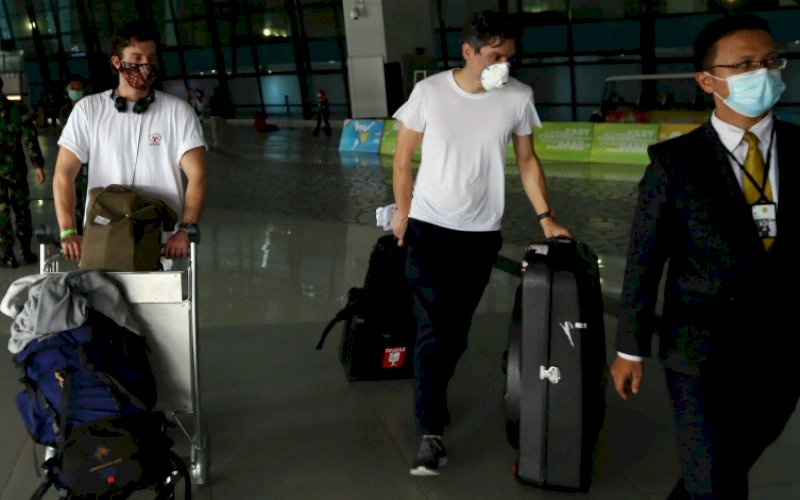 KARANTINA. Dua WNA berjalan untuk mengikuti proses karantina setibanya di Terminal 3 Bandara Soekarno Hatta, Tangerang, Banten, Selasa (29/12/2020). foto: istimewa