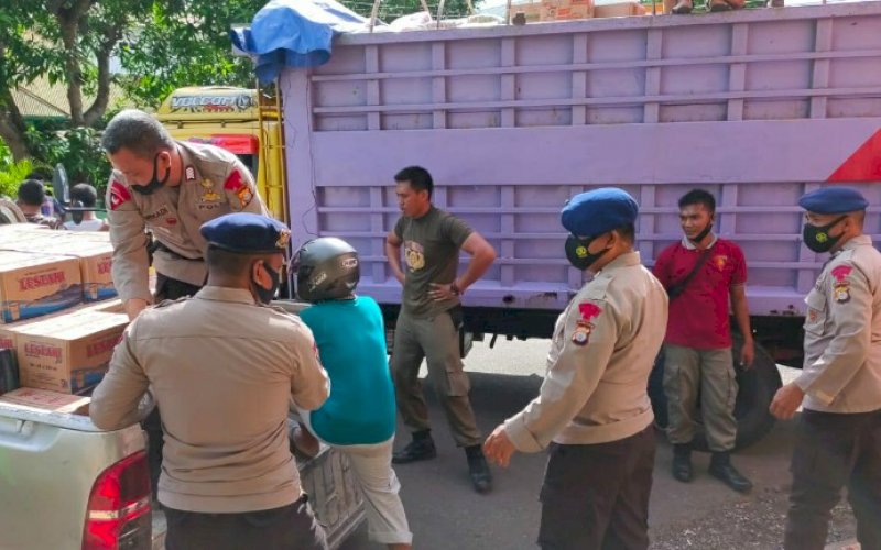 PEMINDAHAN. Personel Batalyon C Pelopor Satbrimob Polda Sulsel diturunkan untuk membantu proses pemindahan bantuan untuk korban gempa Sulbar ke atas mobil di Lapangan Merdeka Kabupaten Bone, Kamis (21/1/2021). foto: humas brimob bone