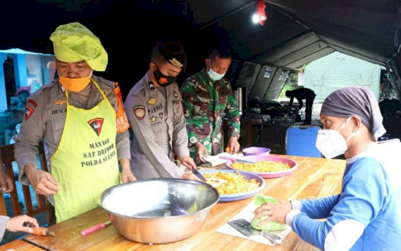 DAPUR LAPANGAN. Aktivitas di dapur lapangan yang disediakan Satbrimob Polda Sulsel di posko pengungsian korban gempa bumi Sulbar, Selasa (19/1/2021). foto: humas satbrimob polda sulsel