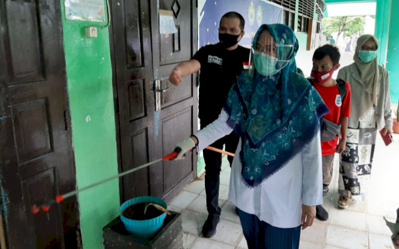 PENYEMPROTAN. Rektor UIM DR Ir Hj Andi Majdah M Zain MSi didampingi Humas IDI Kota Makassar yang juga Kabag Humas dan Kerja Sama UIM dr Wachyudi Muchsin SH memimpin langsung penyemprotan massal di seluruh gedung Kampus UIM, Senin (4/1/2021). foto: doelbeckz/pluz.id