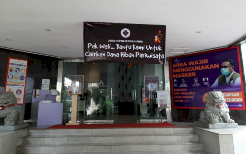 TUNTUTAN. Perhotelan dan restoran memasang spanduk menuntut agar Pj Wali Kota Makassar, Rudy Djamaluddin, membantu mencairkan dana hibah Kemenparekraf. Hal ini seperti terlihat di Almadera Hotel Makassar, Senin (1/2/2021). foto: istimewa