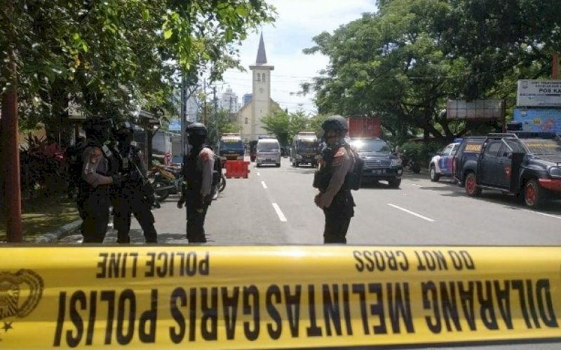 DIJAGA KETAT. Kepolisian melakukan penjagaan dan memasang garis polisi di sekitaran Gereja Katedral Makassar usai terjadi aksi bom bunuh diri di pintu masuk gereja sekitar pukul 10.35 WITA, Minggu (28/3/2021). foto: pluz.id