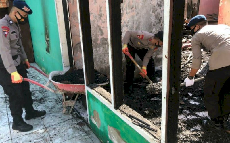 MEMBERSIHKAN. Personel Batalyon C Pelopor Satbrimob Polda Sulsel membantu membersihkan sisa-sisa puing kebakaran yang masih bertumpukan di lokasi kejadian, Jl Sungai Cerekang, Kelurahan TA, Kecamatan Tanete Riattang, Kabupaten Bone, Rabu (3/3/2021). foto: humas brimob bone