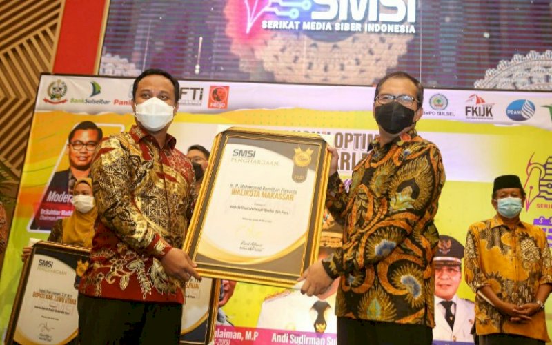 TERIMA PENGHARGAAN. Wali Kota Makassar Moh Ramdhan Pomanto menerima Award SMSI 2021 yang diserahkan Plt Gubernur Sulsel Andi Sudirman Sulaiman di Hotel Claro Makassar, Jumat (26/3/2021). foto: humas pemkot makassar