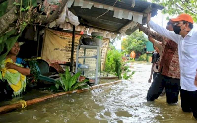 MENYAPA. Wali Kota Makassar, Moh Ramdhan Pomanto, menyapa warga saat meninjau langsung sejumlah titik banjir di Kota Makassar, Kamis (11/3/2021). foto: humas pemkot makassar 