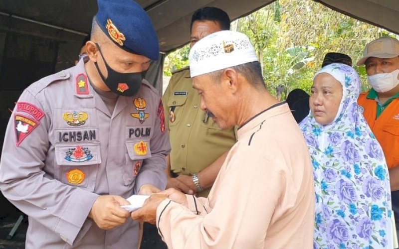 BERI BANTUAN. Danyon C Pelopor Satbrimob Polda Sulsel Kompol Nur Ichsan menyerahkan bantuan kepada korban kebakaran Syahril di Kelurahan Palette, Kecamatan Tanete Riattang Timur, Bone, Selasa (20/4/2021). foto: brimob bone