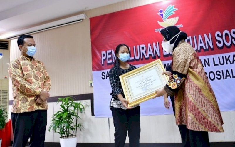 SANTUNAN. Menteri Sosial Tri Rismaharini didampingi Plt Gubernur Sulsel Andi Sudirman Sulaiman menyerahkan santunan kepada keluarga korban KKB Papua dan keluarga korban ledakan bom Gereja Katedral Makassar di Balai Besar Pendidikan dan Pelatihan Kesejahteraan Sosial Makassar, Selasa (20/4/2021). foto: humas pemprov sulsel