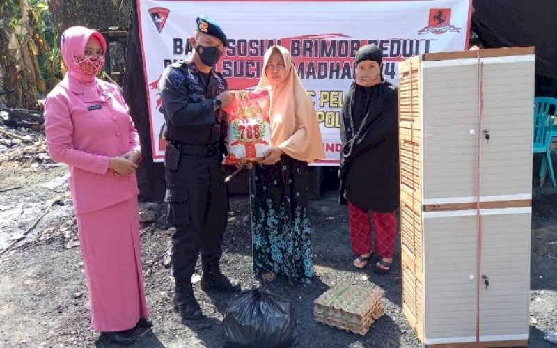 BRIMOB PEDULI. Danyon C Pelopor Satbrimob Polda Sulsel Kompol Nur Ichsan bersama Ketua Bhayangkari Ranting Batalyon C Pelopor Upiek Ichsan menyerahkan bantuan sembako kepada warga, Jumat (23/4/2021). foto: humas brimob bone