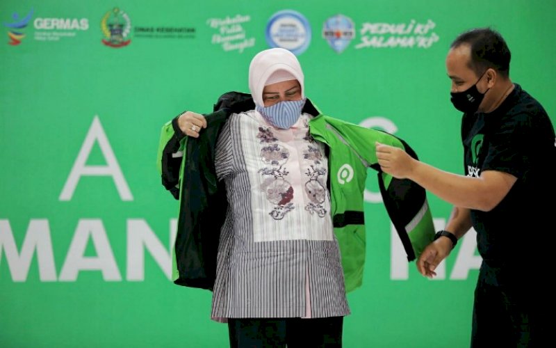 VAKSINASI GOJEK. Senior Manager Public Policy and Government Relations Gojek Sulawesi Mohammad Khomeiny menyerahkan jaket&nbsp; Gojek kepada Ketua TP PKK Makassar Indira Jusuf Ismail sebagai tanda dimulainya vaksinasi kepada 600 mitra Gojek di Phinisi Point (PIPO) Mall Makassar, Sabtu (3/4/2021). foto: humas pemkot makassar