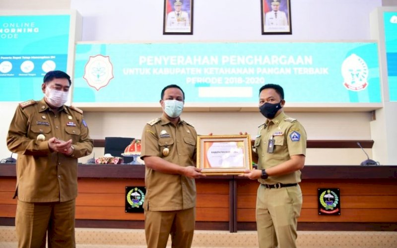PENGHARGAAN. Plt Gubernur Sulsel Andi Sudirman Sulaiman disaksikan Sekda Provinsi Sulsel Abdul Hayat Gani menyerahkan langsung penghargaan kepada Bupati Bantaeng Ilham Syah Azikin sebagai Kabupaten Dengan Ketahanan Pangan Terbaik Periode 2018-2020 di Ruang Rapat Pimpinan (Rapim) Kantor Gubernur Sulsel, Senin (7/6/2021). foto: humas pemprov sulsel