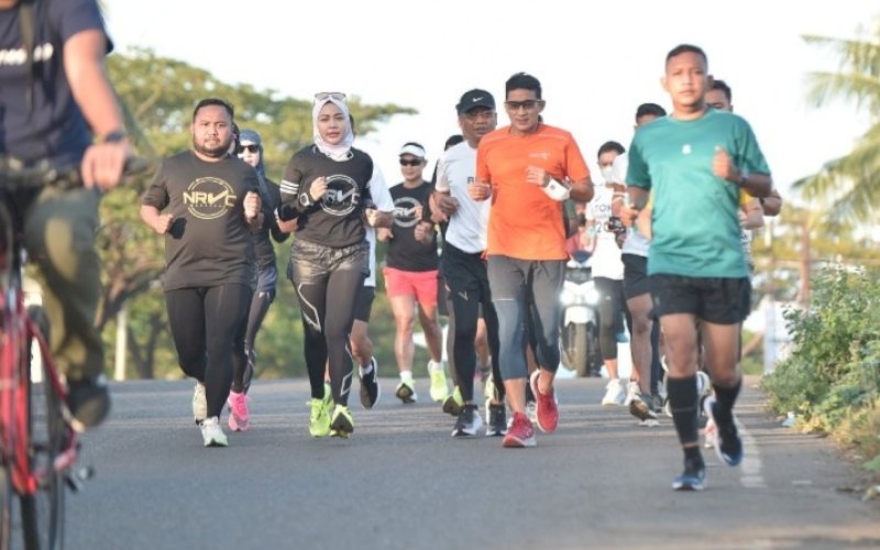 BERLARI. Menteri Pariwisata dan Ekonomi Kreatif RI, Sandiaga Salahuddin Uno (kedua kanan), menyempatkan berlari menjelajahi Makassar bersama komunitas lari NRVC (Night Run Vercity), Jumat (18/6/2021) pagi. foto: humas pemkot makassar