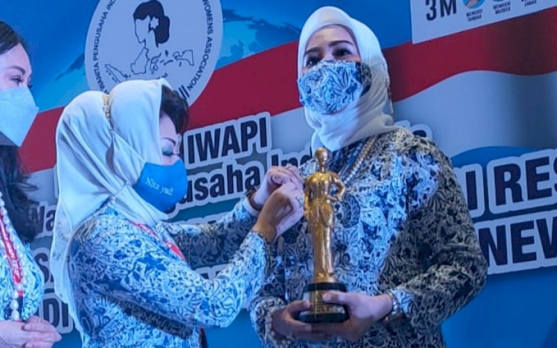 JUARA SATU. Ketua Umum DPP IWAPI Nita Yudi menyerahkan penghargaan kepada Ketua Umum DPD IWAPI Provinsi Sulsel Ainun Jariah sebagai Juara 1 Perempuan Pengusaha Berprestasi Tingkat Nasional 2021 pada Munas IX IWAPI di Hotel JW Marriott Jakarta, Jumat (18/6/2021). foto: istimewa