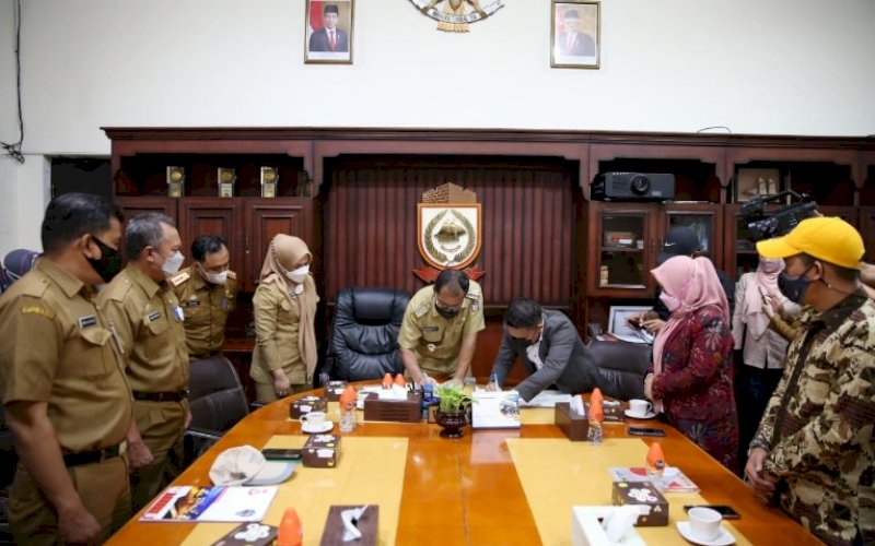 KERJA SAMA. Wali Kota Makassar, Moh Ramdhan Pomanto, menandatangani nota kesepahaman dengan KPU Kota Makassar di Balai Kota Makassar, Senin (5/7/2021). foto: istimewa