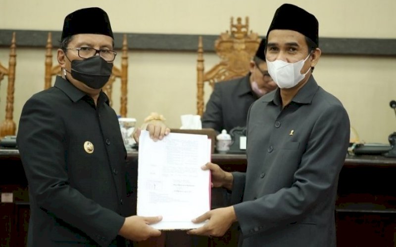 PENYERAHAN. Ketua DPRD Kota Makassar Rudianto Lallo (kanan) menyerahkan draf Laporan Pertanggungjawaban Pelaksanaan APBD 2020 Kota Makassar yang telah disahkan menjadi peraturan daerah pada rapat paripurna di DPRD Makassar, Rabu (7/7/2021). foto: istimewa