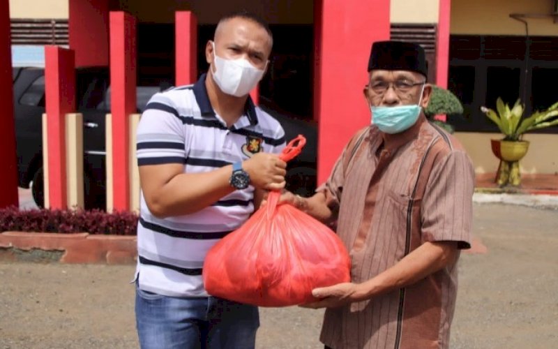 BERBAGI. Danyon C Pelopor Satbrimob Polda Sulsel, Kompol Nur Ichsan, membagikan daging kurban kepasa warga di Mako Batalyon C Pelopor Satbrimob Polda Sulsel di Bone, Selasa (20/7/2021). foto: istimewa