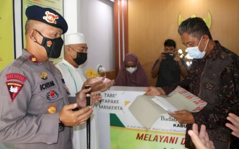 PENYERAHAN ZAKAT. Danyon C Pelopor Satbrimob Polda Sulsel, Kompol Nur Ichsan, menyerahkan zakat profesi atau zakat maal kepada Baznas Kabupaten Bone, Kamis (22/7/2021). foto: istimewa