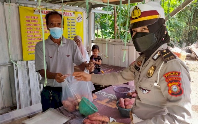 DITLANTAS PEDULI. Personel Ditlantas Polda Sulsel, menyerahkan bantuan kepada pedagang kaki lima di Kota Makassar, Rabu (4/8/2021). foto: istimewa