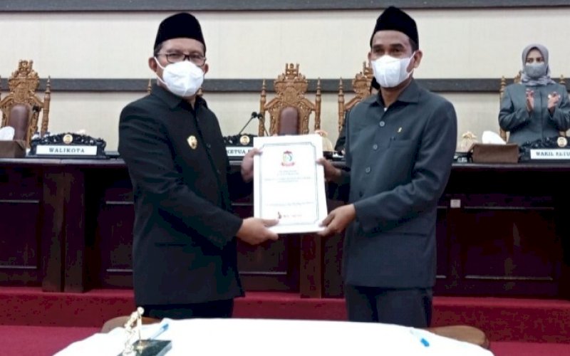 PENYERAHAN. Ketua DPRD Kota Makassar Rudianto Lallo (kanan) menyerahkan draf mengesahkan Rancangan Peraturan Daerah PD Pasar menjadi Perumda Pasar Makassar Raya kepada Wali Kota Makassar Moh Ramdhan Pomanto, Rabu (4/8/2021). foto: istimewa