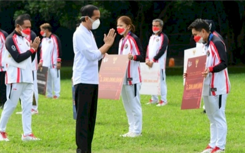 PENYERAHAN BONUS. Presiden Joko Widodo menyerahkan bonus apresiasi bagi para atlet dan pelatih Indonesia yang berlaga di Olimpiade Tokyo 2020 di halaman Istana Kepresidenan Bogor, Jawa Barat, Jumat (13/8/2021). foto: istimewa