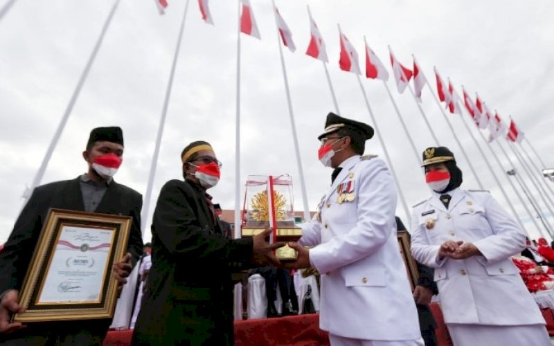 PENGHARGAAN. Wali Kota Makassar, Moh Ramdhan Pomanto, menyerahkan penghargaan kepada sembilan orang tokoh dinilai telah mengharumkan nama Makassar hingga ke tingkat nasional bahkan dunia di Anjungan Pantai Losari Makassar, Selasa (17/8/2021). foto: istimewa