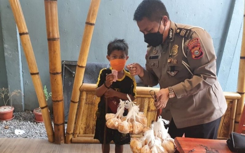PEDULI. Kasi Fasmat Ditlantas Polda Sulsel, AKP Ade Firmansyah, memborong dagangan bocah penjual buah tala keliling asal Kabupaten Jeneponto, Jumat (21/8/2021) petang. foto: istimewa