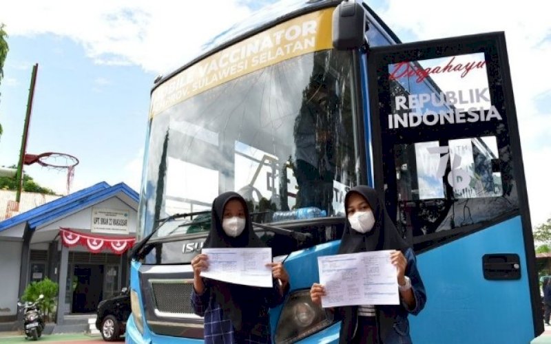 DIVAKSIN. Dua orang pelajar memperlihatkan keterangan telah divaksin, belum lama ini. foto: istimewa