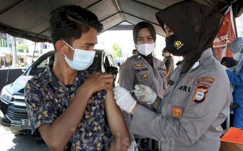 VAKSINASI. Anggota Polri melakukan vaksinasi kepada salah satu peserta vaksinasi. foto: istimewa