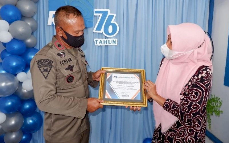 TERIMA PENGHARGAAN. Danyon C Pelopor Kompol Nur Ichsan menerima piagam penghargaan yang diserahkan langsung Koordinator RRI SP Bone Sabariah, Jumat (10/9/2021). foto: istimewa