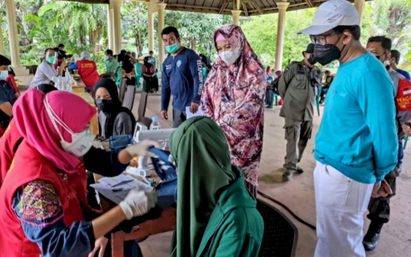 MEMANTAU. Ketua Gelora Makassar, EZ Muttaqien Yunus (kanan), memantau Gebyar Vaksin Gelora Indonesia di Monumen Korban 40.000 jiwa Makassar, Sabtu (11/9/2021). foto: istimewa
