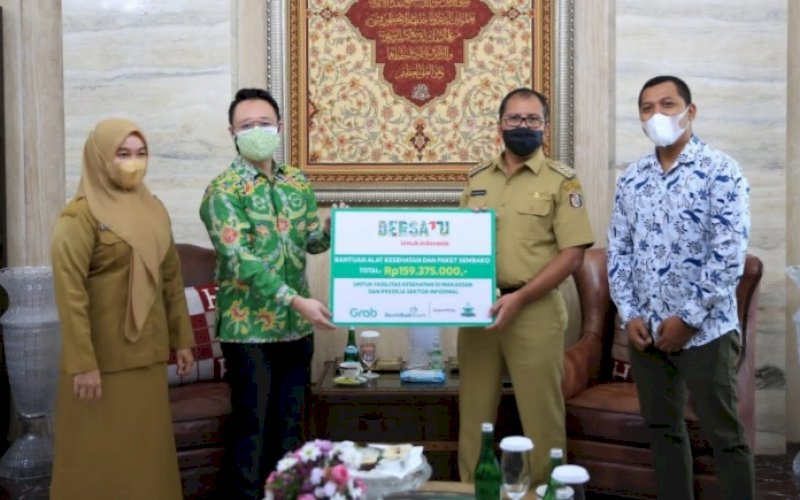 SERAHKAN BANTUAN. Direktur Indonesia Timur Grab Indonesia Halim Wijaya (kiri) menyerahkan bantuan kepada Wali Kota Makassar Moh Ramdhan Pomanto di kediaman pribadinya, Jl Amirullah, Kota Makassar, Selasa (21/9/2021). foto: istimewa