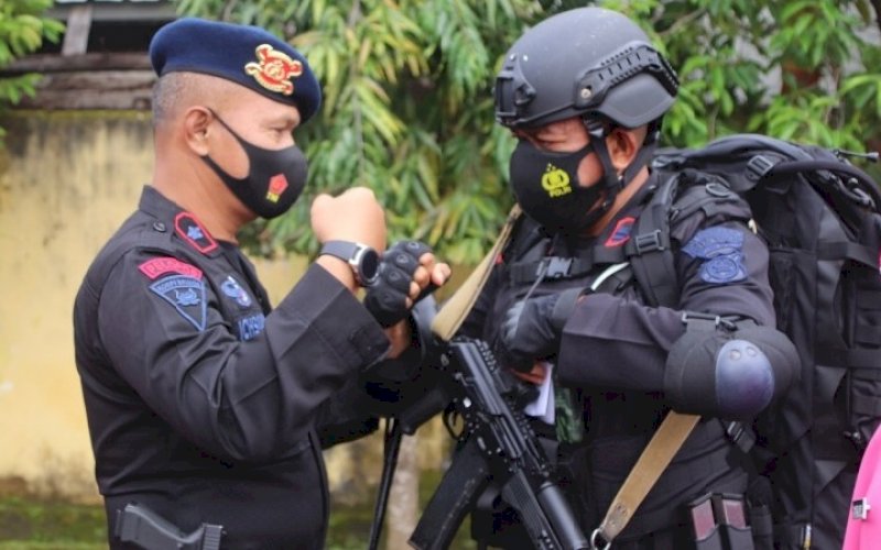 APEL PEMBERANGKATAN. Danyon C Pelopor Satbrimob Polda Sulsel, Kompol Nur Ichsan (kiri), melakukan salam kepada salah satu personelnya pada apel pemberangkatan personel Batalyon C Pelopor Pam PON XX Papua di Lapangan apel Mako Batalyon C Pelopor Satbrimob Polda Sulsel, Kota Watampone, Bone, Jumat (24/9/2021). foto: istimewa
