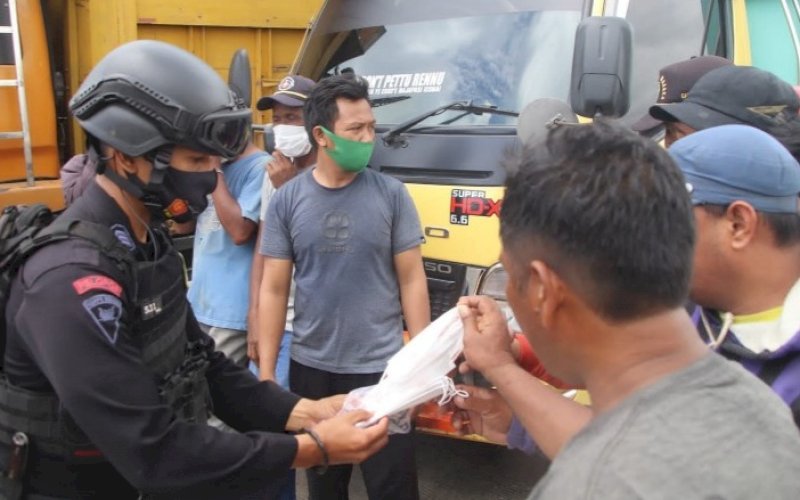 BAGI MASKER. Personel Batalyon C Pelopor Satbrimob Polda Sulsel bersama Baznas Kabupaten Bone membagikan masker kepada warga pada Patroli KRYD, Jumat (1/10/2021). foto: istimewa