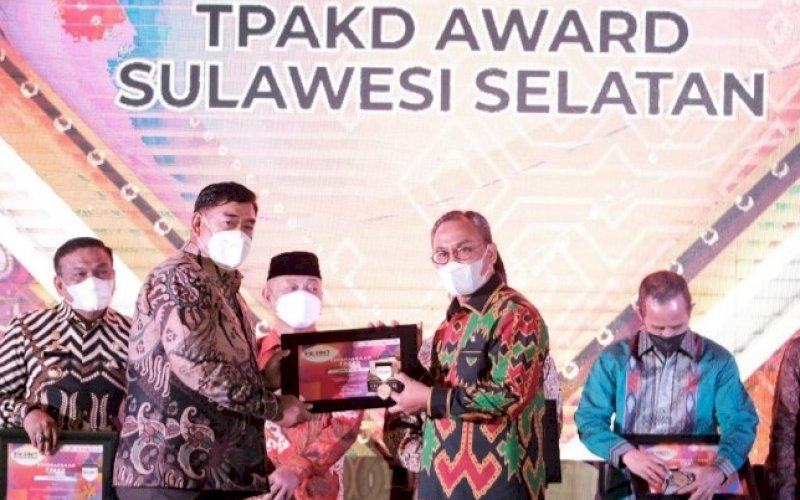 TPAKD AWARD. Sekda Provinsi Sulsel, Abdul Hayat Gani (kiri), menyerahkan TPAKD Award Sulsel kepada para penerima di sela-sela pertemuan tahunan Industri Jasa Keuangan di Toraja Utara yang dirangkaikan dengan Opening Ceremony Toraja Highland Festival, Senin (4/10/2021). foto: istimewa