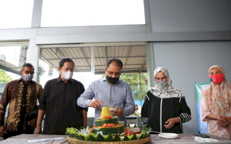 PERESMIAN. Wali Kota Makassar, Moh Ramdhan Pomanto, memotong tumpeng saat meresmikan Klinik Swab House Prof Bachtiar Razak di Jl AP Pettarani (samping MCD), Jumat (8/10/2021). foto: istimewa